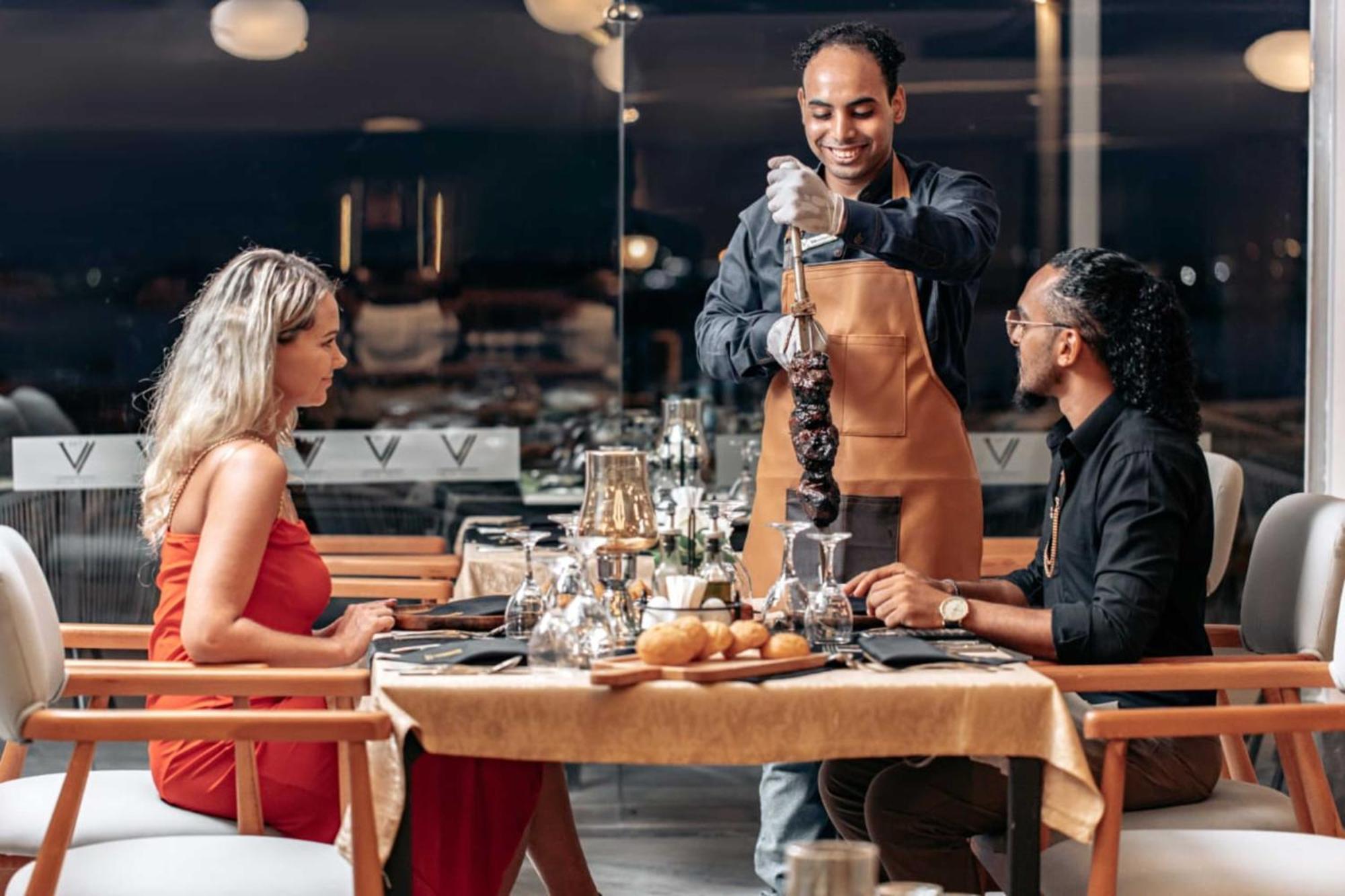 The V Luxury Resort Sahl Hasheesh Hurghada Exterior foto A waiter serving a couple at a restaurant